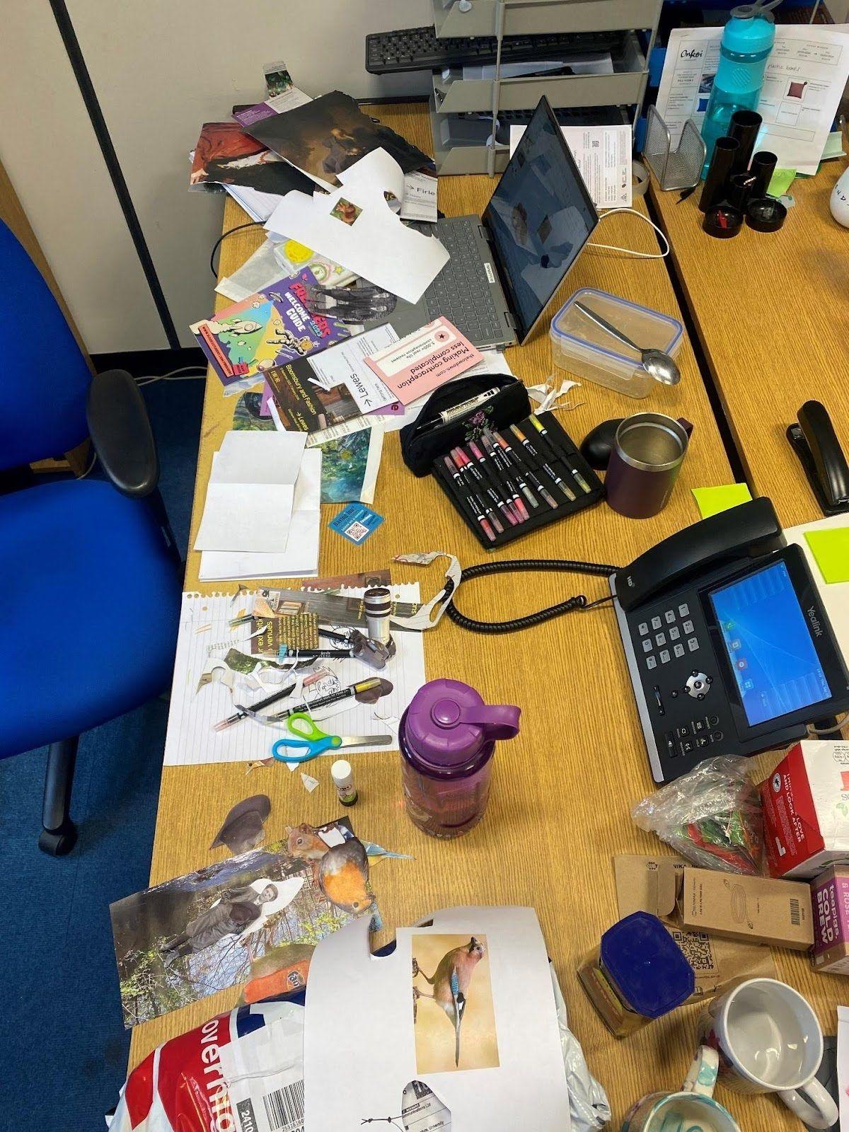 A desk filled with paper and cut outs