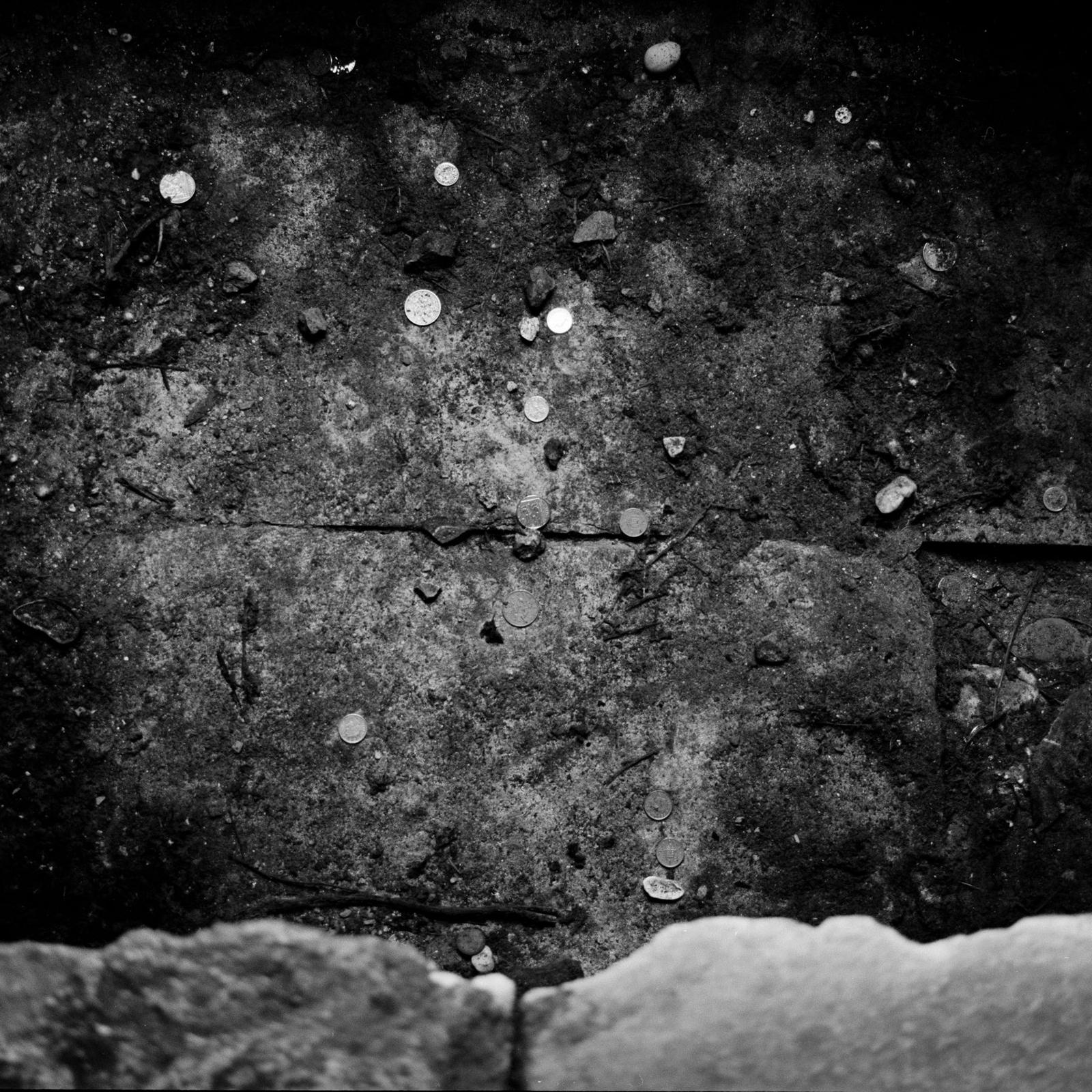 A grainy, black and white, abstract photo of tiles and a masonry wall